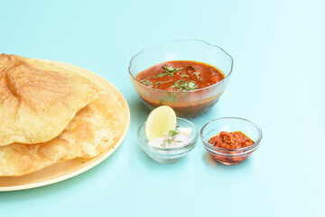 Indian dish spicy Chick Peas curry also known as Chole Bhatura and Chana Masala or Chole or Chickpeas Masala curry,traditional north indian lunch served with fried puri or flatbreads,selective focus