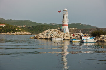 Lighthouse with turkish flag at the entrance to a harbor, city of Kas, Turkey