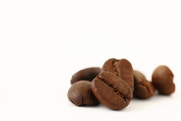Roasted coffee beans on white background with copy space.