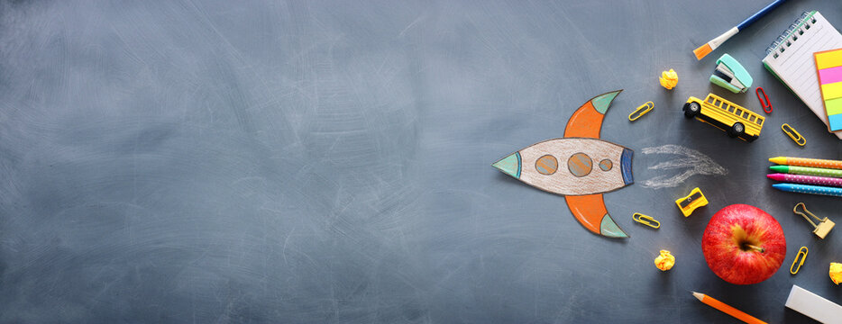 education. Back to school concept. rocket cut from paper and painted over blackboard background. top view, flat lay