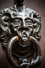 Antique metal door knocker with face