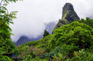 Iao Needle is a landmark rock ledge inside Iao Valley State Park with lush evergreen rainforest...
