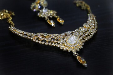 Indian style gold imitation jewelry that is necklace with stoles and long earrings