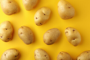 Potatoes on yellow background. Image top view, flat lay, and copy space.