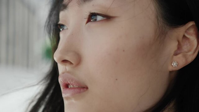 Pretty face young asian woman portrait looking away serious confident beautiful young urban casual natural city slow motion