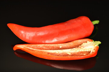 Red organic bell peppers, close-up, on a black background.