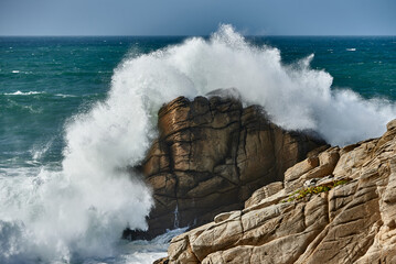 Brandung an einem Felsen mit spritzender Gicht auf Quiberon in der Bretagne in Frankreich