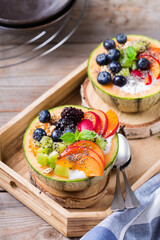 Fruit salad with yogurt in carved melon cantaloupe bowl