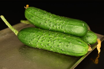 Fresh green cucumbers, close-up, isolated on black.