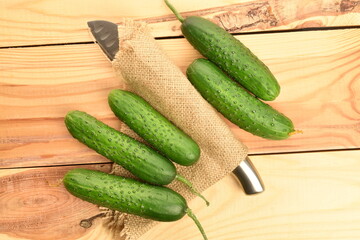 Fresh green cucumbers, close-up, on a wooden table.