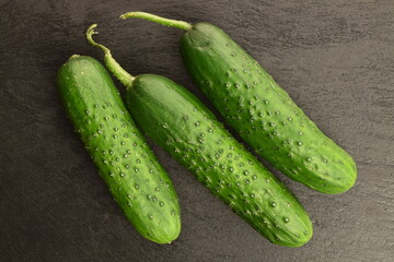 Fresh green cucumbers on a slate board.