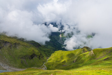 Fototapeta na wymiar Austrian Alps with white clouds on the low altitude