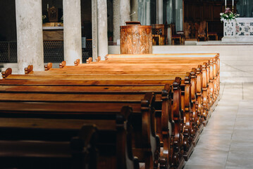 Wooden benches under sun rays in an empty cathedral