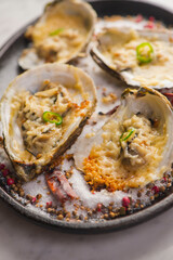 Oysters Rockefeller. Oysters topped with cheese, cream, garlic onions oven baked and garnished with fresh diced jalapeños. Classic American restaurant or French bistro appetizer.