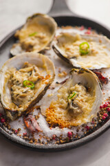 Oysters Rockefeller. Oysters topped with cheese, cream, garlic onions oven baked and garnished with fresh diced jalapeños. Classic American restaurant or French bistro appetizer.