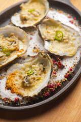 Oysters Rockefeller. Oysters topped with cheese, cream, garlic onions oven baked and garnished with fresh diced jalapeños. Classic American restaurant or French bistro appetizer.