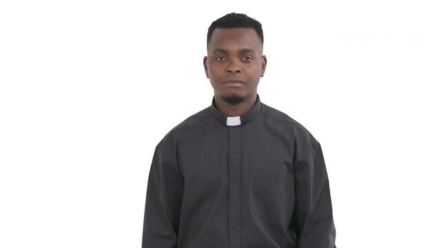 Portrait of handsome African priest connecting thumb and forefinger in a circle and holding another fingers straight showing okay sign with both hands isolated on white background