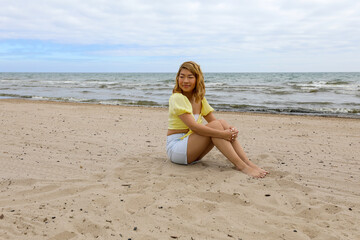 Fototapeta na wymiar Beautiful young woman relaxing on the beach in the morning.