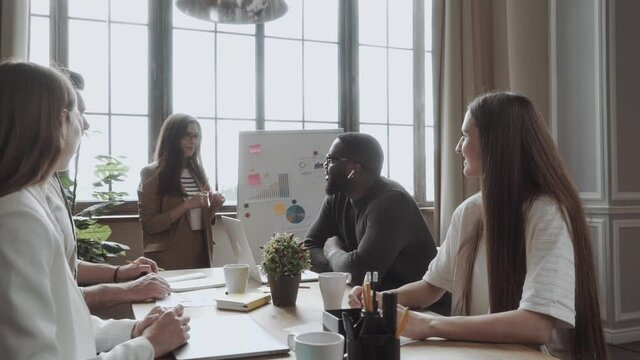 team of young colleagues conducting a business presentation using flipchart while working in the creative office