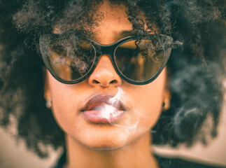 Girl smoking, smoke comes out of her mouth