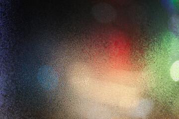 Water drops on wet window glass with city lights.
