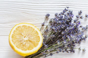 Fresh lavender with lemon slice on white wooden background