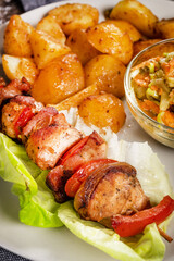 Shish kebab served with roasted potatoes and salad.