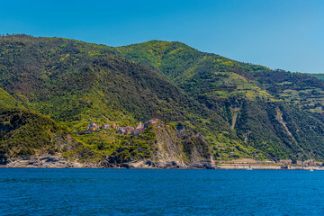 A view looking back towards the cliff top settlement of Corniglia and railway station in the summertime