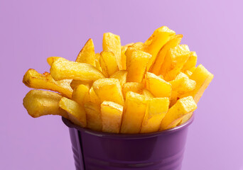 French fries close-up. Deep-fried food. French fries on purple background