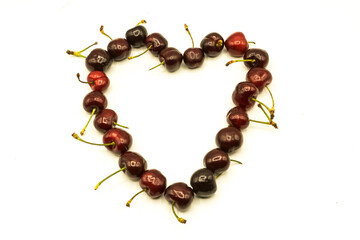 Lots of red cherries making heart shape with background and inside in white