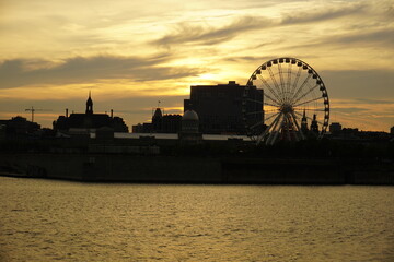 Obraz premium A skyline of Montreal Old Port at sunset. Foreground is Saint Laurent river