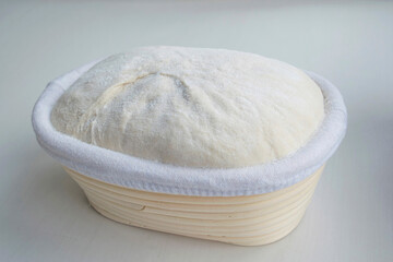 Sourdough homemade dough in a rattan basket. In natural daylight
