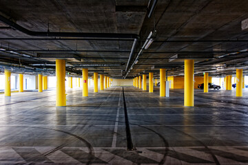 Parking garage, underground interior with a few parked cars