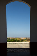 Paisaje visto a través de puerta con arco.