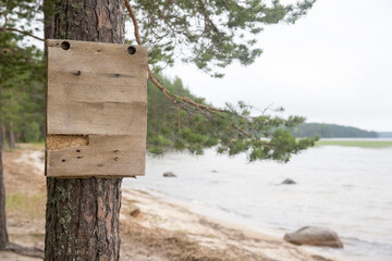 A sign on a tree near the water, mock-up. Karelia.