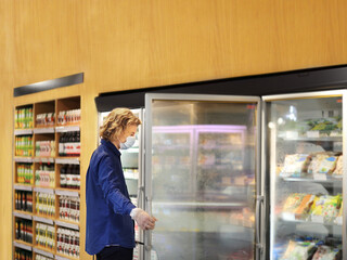 supermarket shopping, face mask and gloves,Man choosing frozen food from a supermarket freezer	
