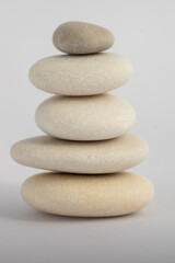 Fototapeta na wymiar One simplicity stones cairn isolated on white background, group of five white pebbles in tower