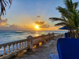 LENS FLARE: Golden sunset shines on an oceanfront terrace of a luxury hotel.