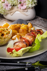 Shish kebab served with roasted potatoes and salad.