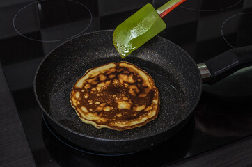 Cook fries pancakes in a pan on an induction cooker	
