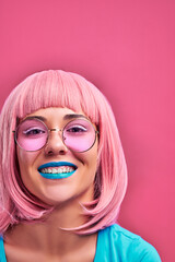 Laughing girl with pink hair, blue lips and sunglasses. Stylish hair color trend.