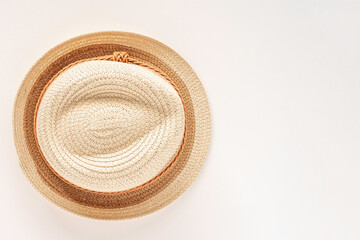 Straw hat on white background with copy space. Top view.