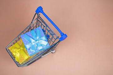 Shopping carts with gifts inside on a beige background.