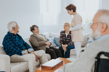 Head nurse is talking to new patients sitting on the sofa in a retirement home