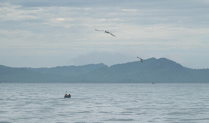 Fototapeta na wymiar Fishermen fish on the sea dike in the morning in Banda Aceh, Indonesia