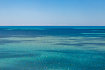 Light and shade in the ocean, with a clear sky overhead