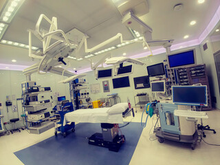 Operating theater  (room) in a modern hospital interior shot with bed in the middle and anesthesiology equipment. no people