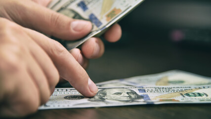 Businessman counting hundred dollar bills.
