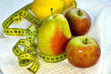 Healthy fruits. Pears, apples, lemons and a centimeter tape close-up. Diet for weight loss.