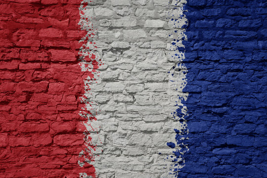 painted big national flag of france on a massive old brick wall